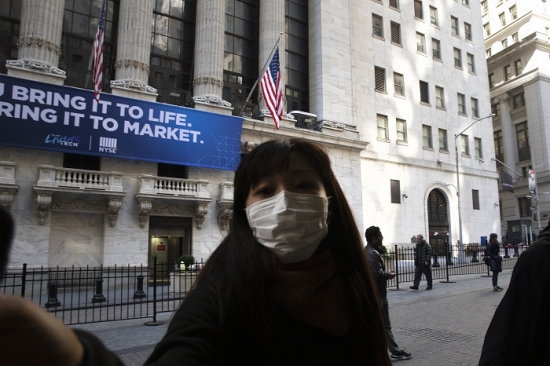 마스크 쓴 시민이 뉴욕증권거래소 앞을 지나가는 모습. /사진=AP, 뉴시스.