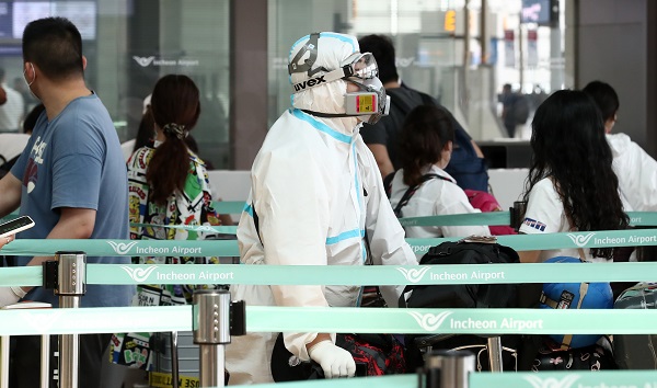 지난 24일 인천국제공항 출국장에서 방역복을 착용한 승객이 수속을 기다리고 있다. /사진=뉴시스.